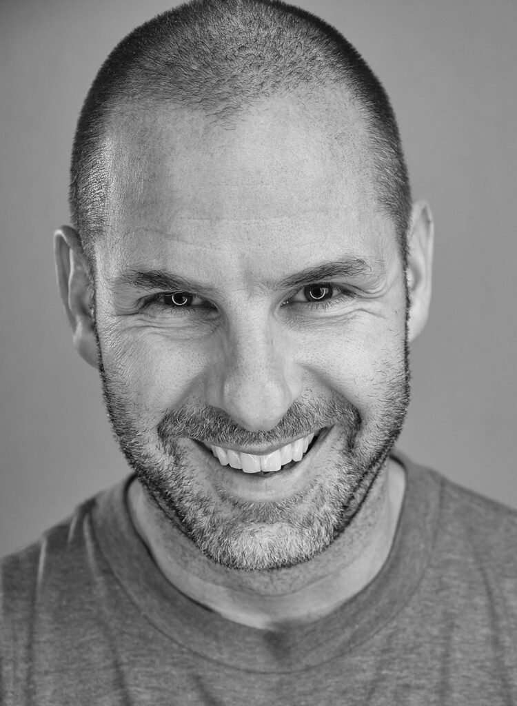 Happy man with a bright smile, close-up black and white portrait, professional photography for Canmore, Banff, and Calgary wedding photography; celebrating joy and connection.