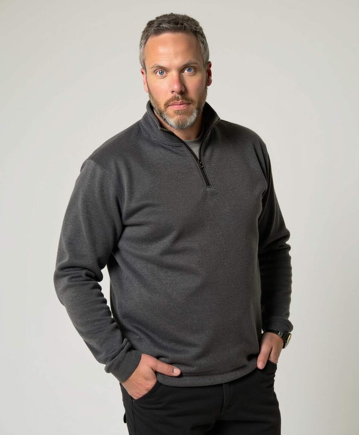 Portrait of a confident middle-aged man wearing a dark grey quarter-zip fleece, standing against a plain light background, suitable for Chinook Photography Canmore Banff Calgary wedding photography.