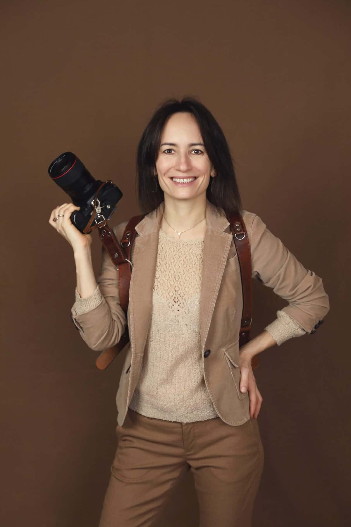 Professional wedding photographer woman holding camera in studio for Chinook Photography Canmore Banff and Calgary Wedding Photographers.