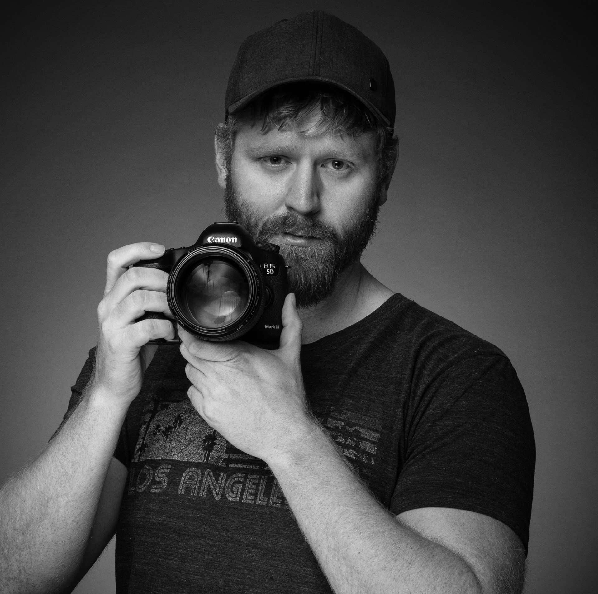Professional photographer holding Canon DSLR camera for wedding, landscape, and portrait photography in Calgary, Canmore, and Banff, Alberta.